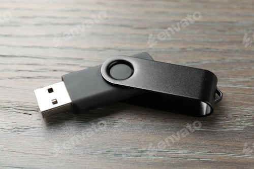 Preview: One flash drive on wooden background, closeup