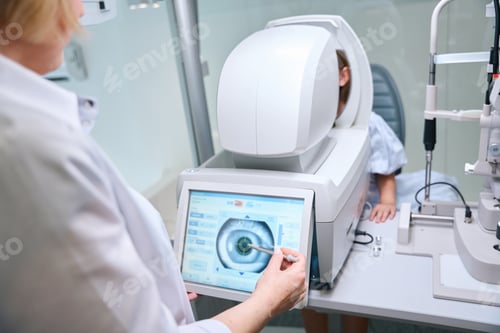 Preview: Ophthalmologist taking automated objective refraction measurement in child