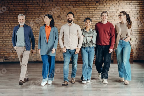 Preview: Diverse group of smiling business team walking together in modern office