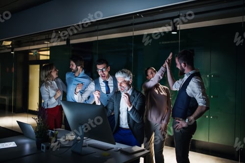 Preview: A group of business people with computer in an office, expressing excitement.