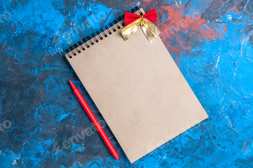 Preview: top view a notepad with little bow red pencil on blue background with copy place