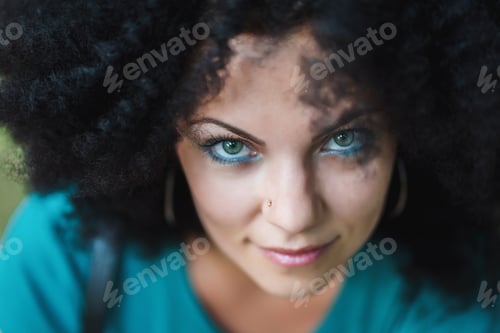 Preview: Young pretty woman with african curly hairstyle. Beautiful girl outdoor.