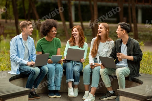Preview: Diverse Multicultural Students Studying Outdoors With Different Electronic Devices, Sitting On Bench