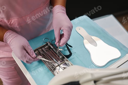 Preview: Holding Dental Instruments in Gloves Preparing for Procedure
