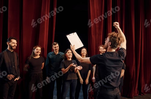 Preview: Group of actors in dark colored clothes on rehearsal in the theater