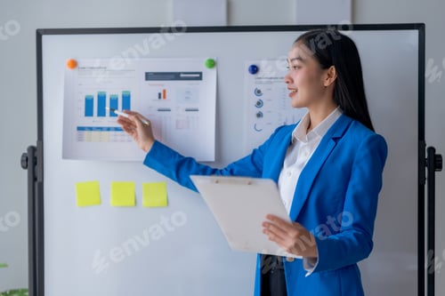 Preview: Professional businesswoman giving business presentation with charts on whiteboard