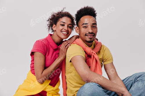 Preview: Positive man and woman looking with smile into camera on isolated background. Happy guy in yellow t