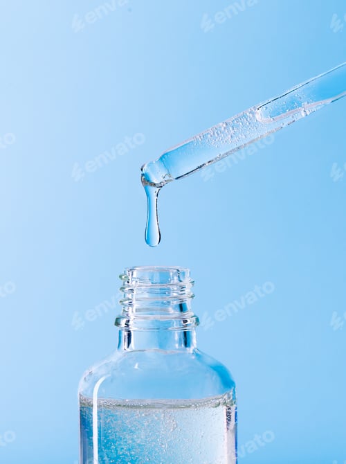 Preview: serum pipette close-up with falling drop on blue background