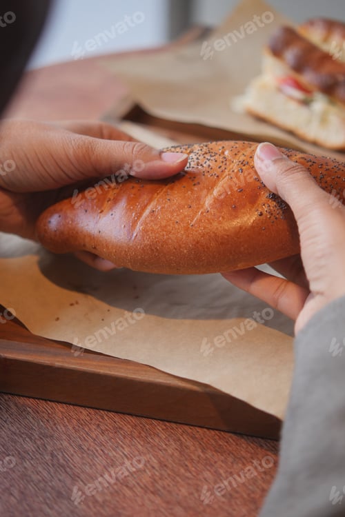 Preview: Hands hold a fresh bread on a wooden tray