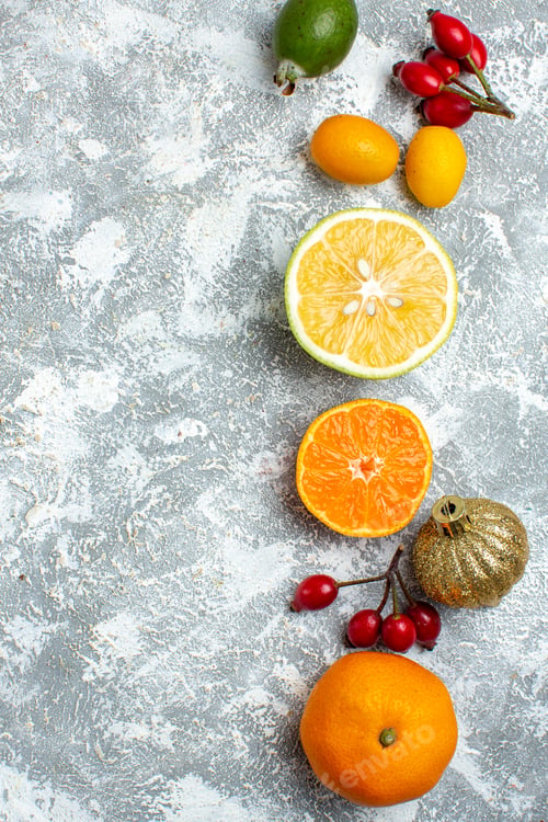 Preview: top view cut lemons feijoas mandarins on grey background with free space