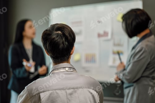 Preview: Attentive young businessman listening to a presentation in office conference room.