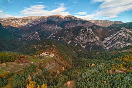 Preview: Mountain range viewed from above, surrounded by a dense forest