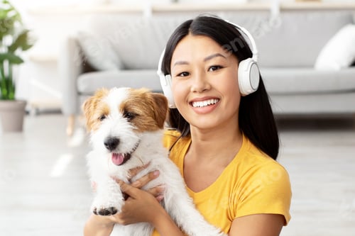 Preview: Pretty asian woman resting with her pet at home