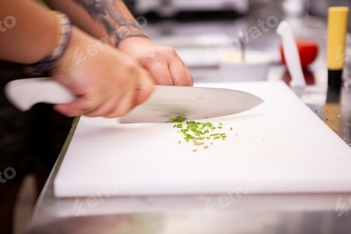 Preview: Chef slicing greenery on white cutting table