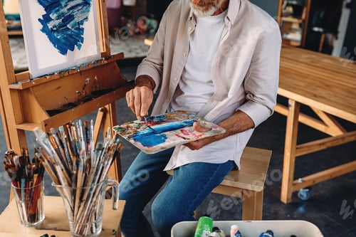 Preview: Unrecognizable artist holding a palette and a painting knife