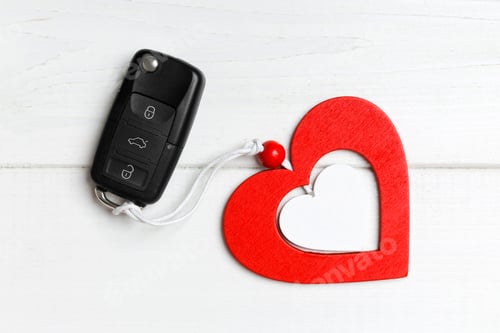 Preview: Top view of car key and heart as a present for Valentine's day on wooden background. Romance concept