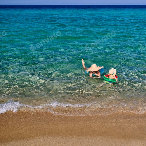 Preview: Two Year Old Toddler Boy On Beach With Mother Swimming With Inflatable Ring. Summer Family