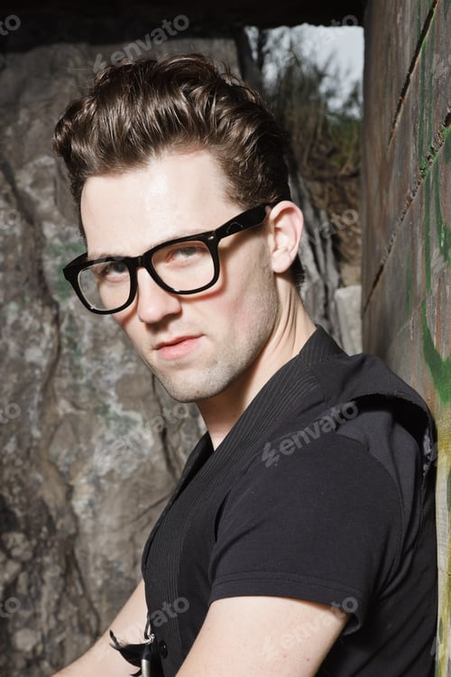 Preview: Urban Style Handsome Young Man With Fifties Hairstyle Dressed In Black Wearing Glasses