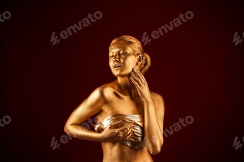 Preview: Portrait of beautiful lady with gold paint on skin against color background