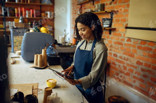 Preview: Female barista in apron take orders in cafe