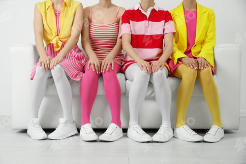 Preview: Women wearing colorful tights sitting on sofa indoors, closeup