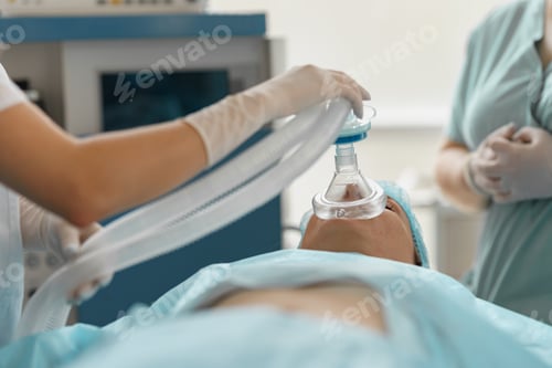 Preview: Close up hands of doctor anesthesiologist holding breathing mask on patient face during operation