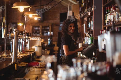 Preview: Young waiter using a electronic machine