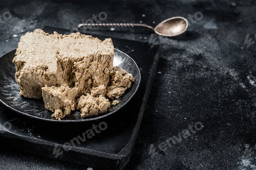 Preview: Homemade sunflower halva with honey. Black background. Top view. Copy space