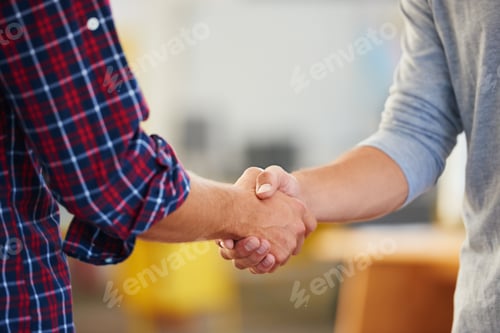 Preview: The start of a perfect partnership. Closeup shot of two men shaking hands in a casual office.