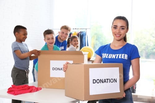 Preview: Volunteers with children sorting donation goods indoors
