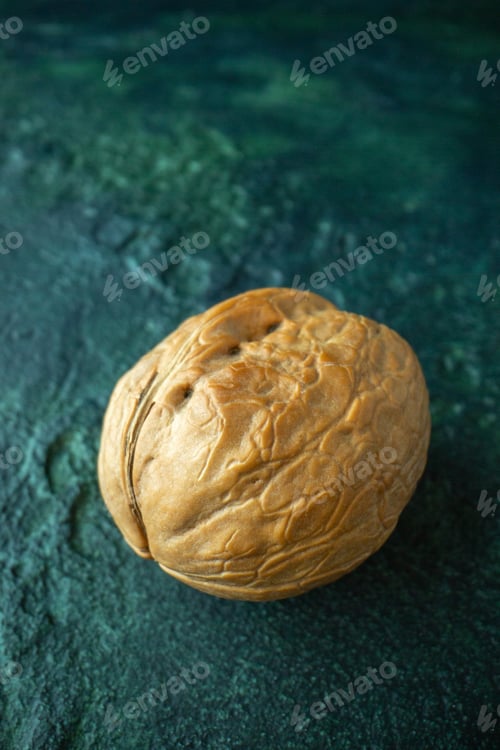 Preview: Top view of whole walnut on blue distressed background with free space