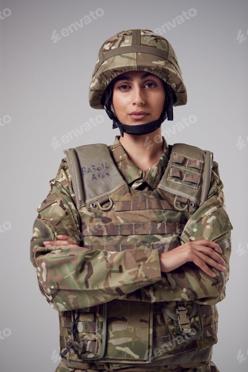 Preview: Studio Portrait Of Serious Young Female Soldier In Military Uniform Against Plain Background