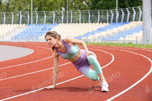Preview: Woman in sportswear suffering from knee pain at stadium