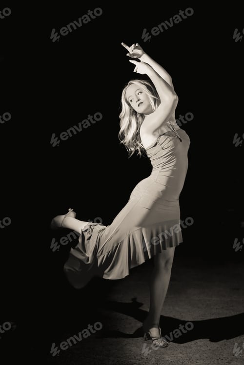 Preview: beautiful dancer in stylish dress with fringe performing tango on black background