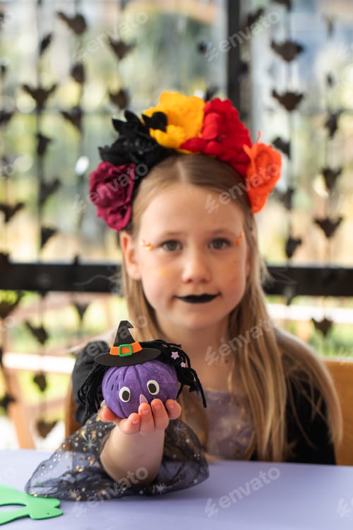 Preview: A children's Halloween party. A little girl in a Halloween costume makes crafts for Halloween.