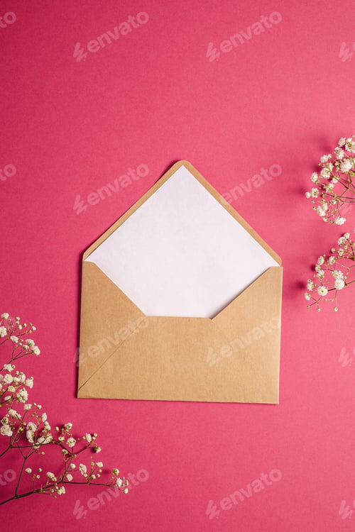 Preview: Kraft brown paper envelope with white empty card, gypsophila flowers, pink background