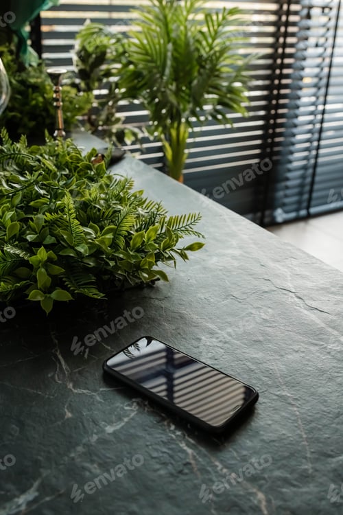 Preview: Black cellphone on the table. Mobile phone on a table.