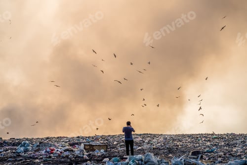 Preview: Person standing on a landfill full of garbage and burning garbage piles