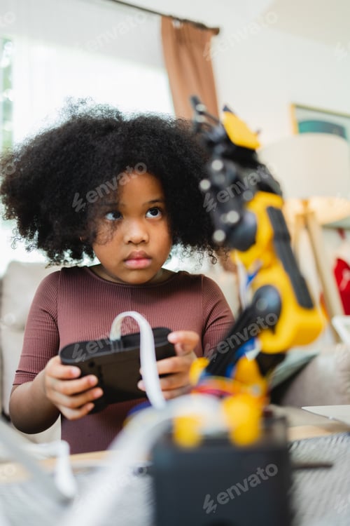 Preview: African American girl learning robotic arms with a program computer.