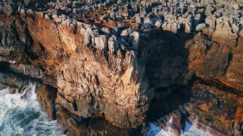 Preview: High rough cliffs scenery washing by foamy stormy waves. Aerial rocky seashore
