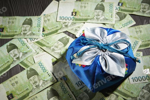 Preview: Closeup of a blue gift bag placed on South Korean won, on a wooden surface