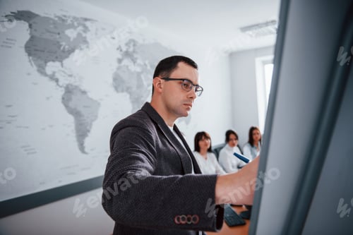 Preview: Serious man. Group of people at business conference in modern classroom at daytime