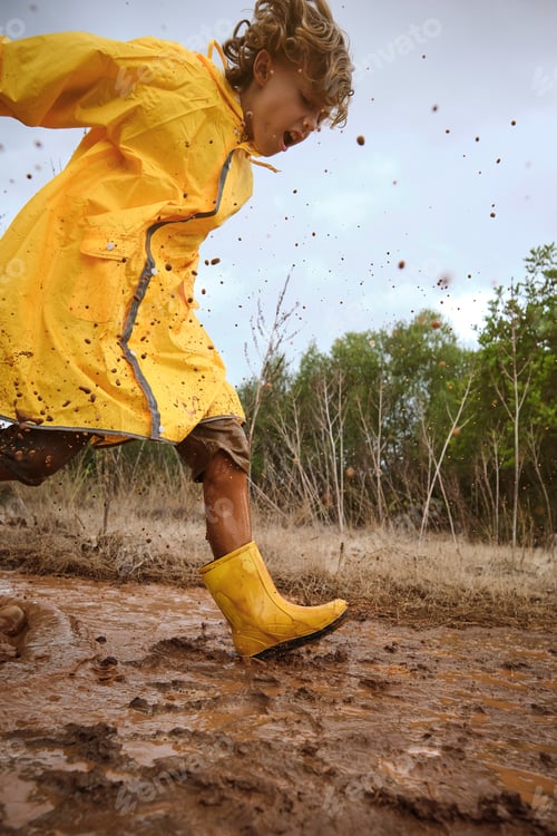 Preview: Preteen boy playing in mud in nature