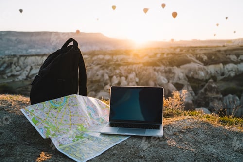 Preview: Laptop and map on hill at dawn