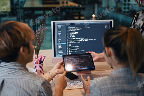 Preview: Back view of IT developer team programming code on computer screen and brainstorming.