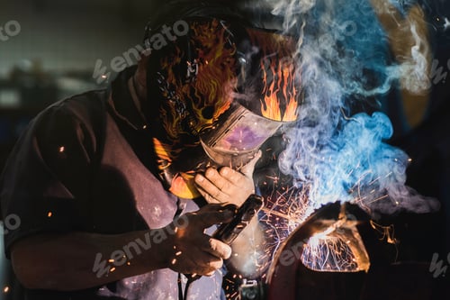 Preview: Beautiful shot of a welder in a cool helmet doing his job