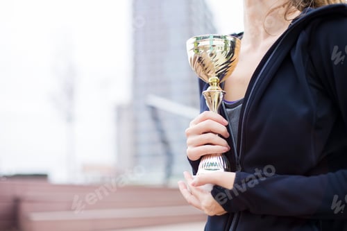Preview: Sport woman holding a trophy