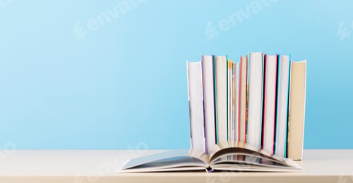 Preview: Old books on a table, with one book open