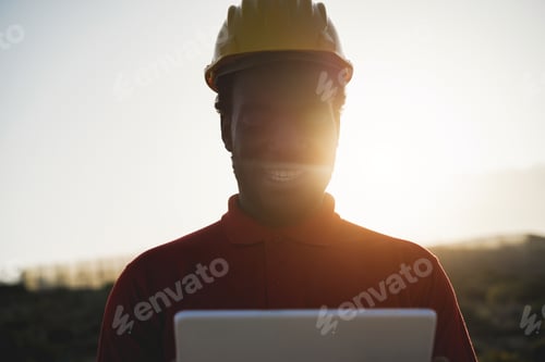 Preview: African engineer man working on construction site with tablet computer - Focus on face