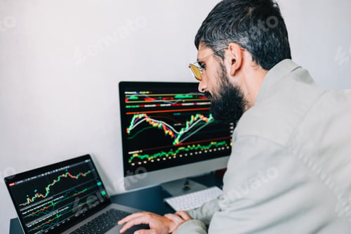 Preview: Caucasian businessman trading online, using computer technology, looking on stock exchange